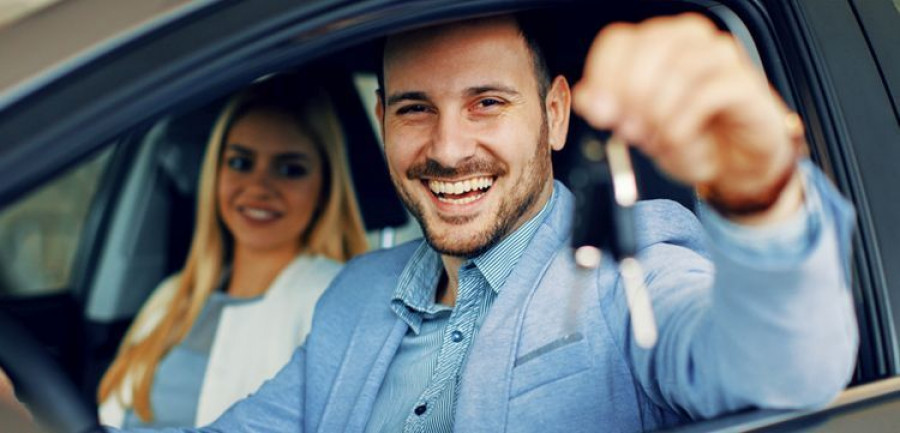 Young couple holding the keys of a new car