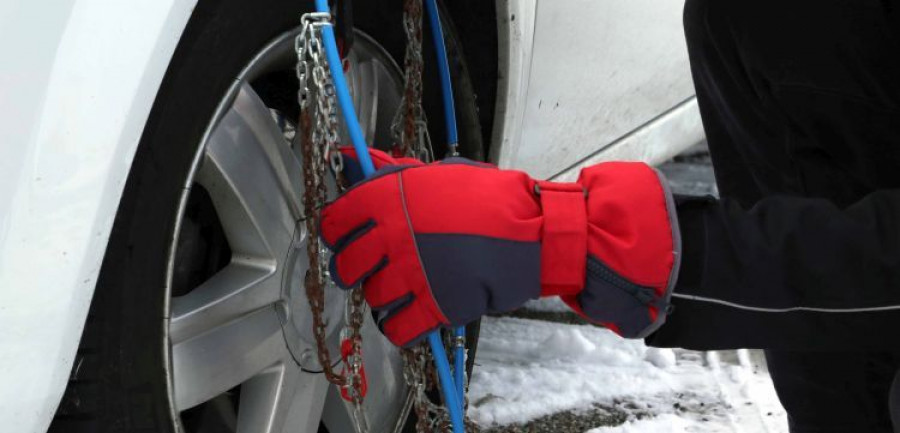 man  mounting snow chains in the car tire