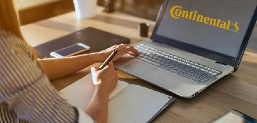 Female designer using laptop, sketching at blank notepad. Woman hand writing in notebook on wooden desk.